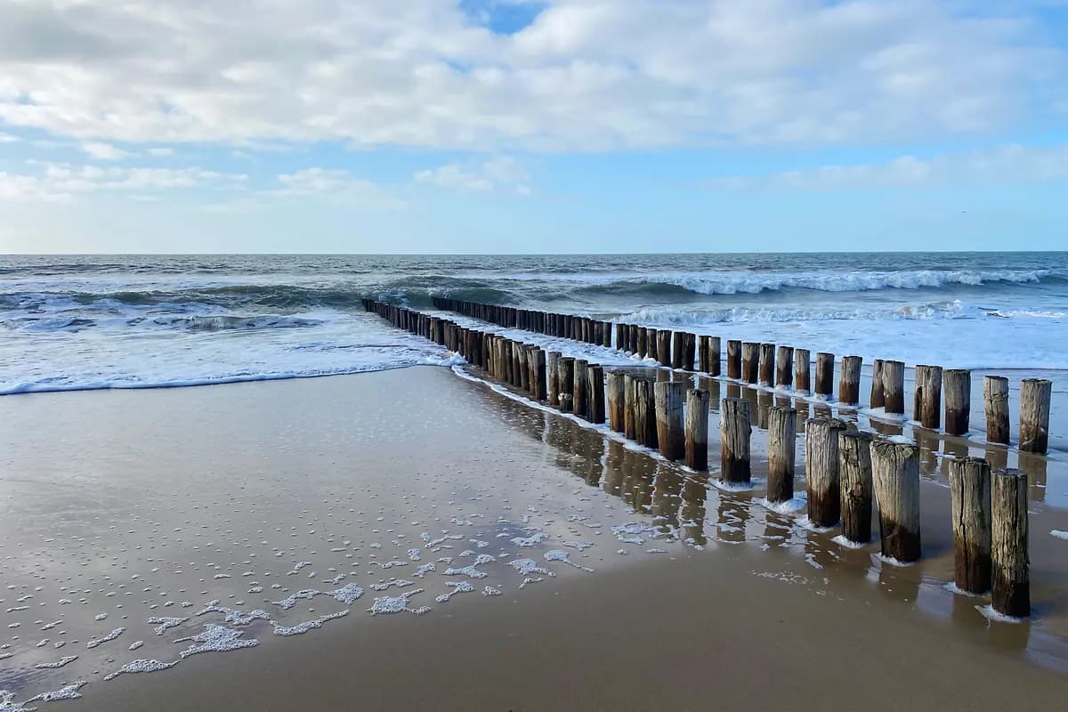 Rustig strand met zee en houten golfbrekers